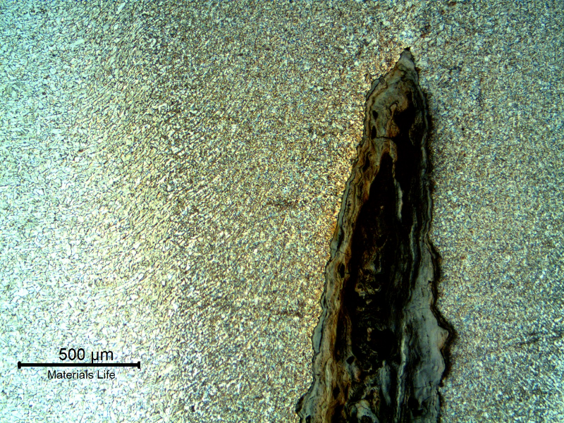 Micrography of the pipe in the leakage area, showing the preferential corrosion in the center of the autogenous weld and oxides inside the crevice, that appearas as a cracking but that is only a localized anodic process.