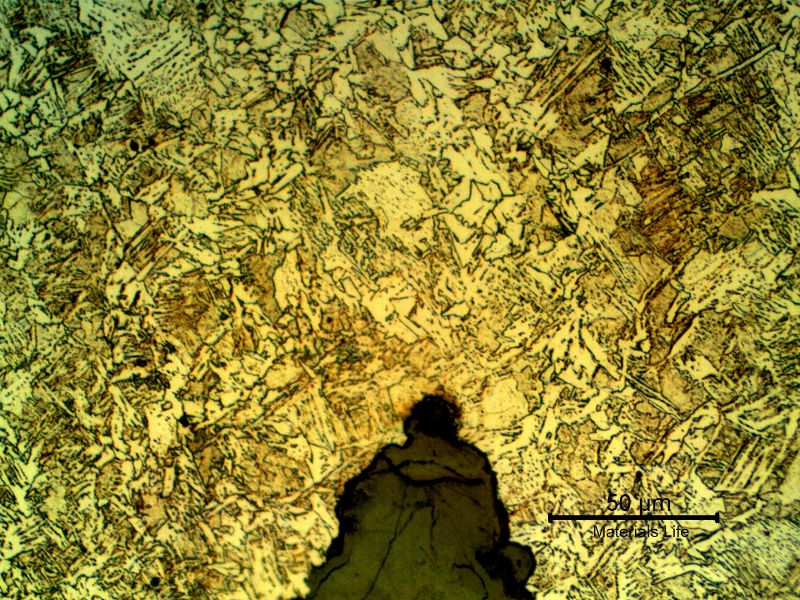 Micrographic detail presenting the slighltly decarburized ferritic structure, with inclusions, in the center of the weld, surrounded by a bainitic structure and the preferential corrosion in the weld.