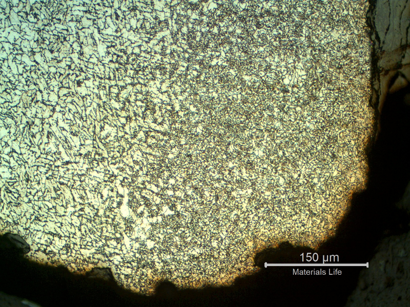 Micrography of the internal pipe surface at the leakage position showing an oxide layer inside the crevice.  The corrosion occurred exactly at the weld metal and the region at the margin of the damage shows the heat affected zone of the autogenous weld, with a refined grain size.