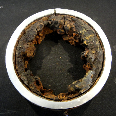 Aspect of a transverse section of the 4" pipe showing the barnacles adhered to the internal pipe surface, and the leakage position (in the top of the figure).  It is possible to see that the deposits are attached all throught the internal pipe perimeter but the damage is localized.  The damage morphology suggests it is a crack, or a welding defect, but the microstructural analysis indicated that the damage is a galvanic effect at the autogenous seam weld.