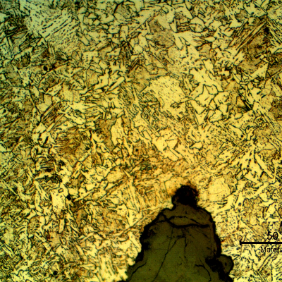 Micrographic detail presenting the slighltly decarburized ferritic structure, with inclusions, in the center of the weld, surrounded by a bainitic structure and the preferential corrosion in the weld.