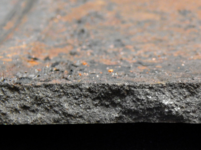 Fracture aspect of the casting cylinder at the 10.5 mm thickness, showing a brittle behavior (lack of plastic deformation). The internal side of the cylinder is to the top of the figure, and the painted surface is to the bottom of the figure.