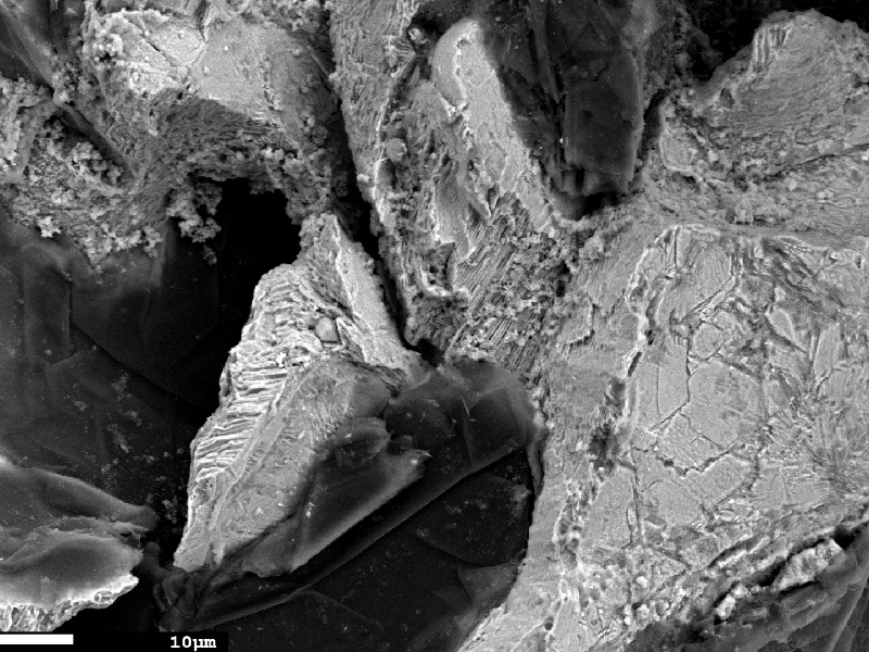 Fractographic detail of the interconnected graphite flakes and corroded matrix.