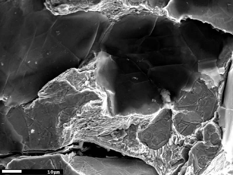 Fractographic detail of the graphite decohesion and cleavage facets in the center of the cast cylinder thickness.