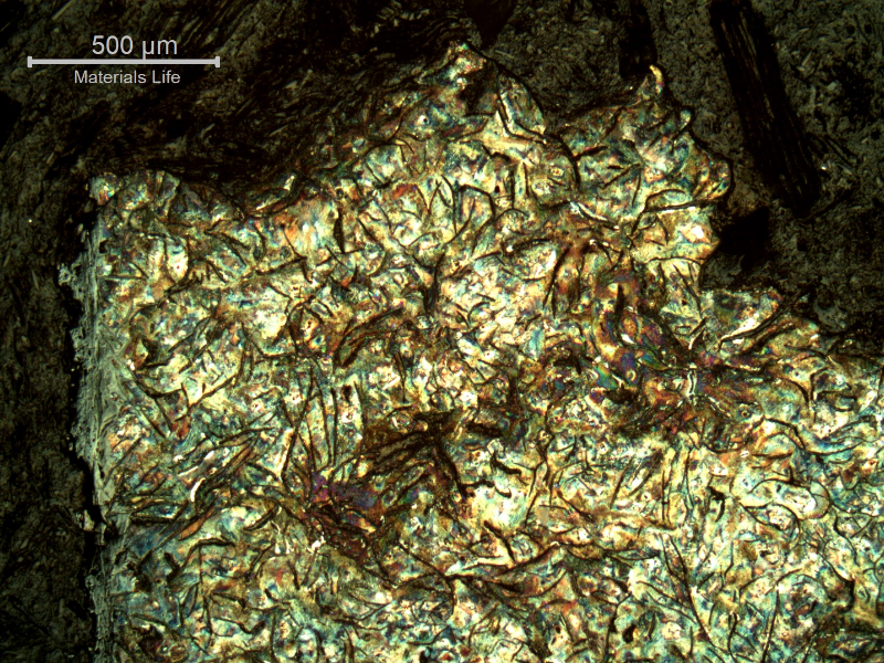 Micrographic aspect of the cast cylinder section at the fracture position (top of the figure), close to the internal surface (left side).  It is possible to see large graphite flakes.