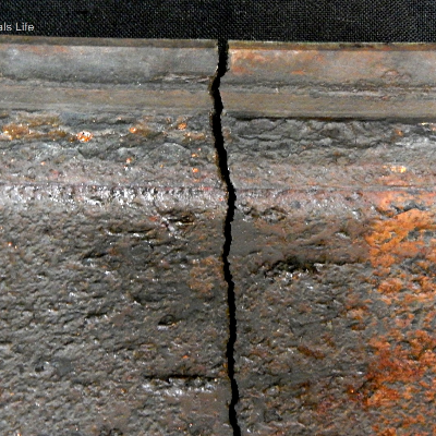 Fractured position of the casting cylinder of 10.5 mm thickness (minimum measured thickness) showing a brittle behavior (lack of plastic deformation), typical of overloading a material with 1% ductility (measured in the tensile test). This is the view of the internal surface of the cylinder, presenting regions of localized thinning in this surface that was in contact with (treated) cooling water.  The external side of the cylinder was painted.