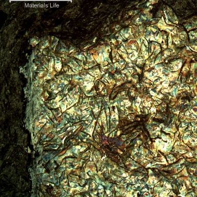 Micrographic aspect of the cast cylinder section at the fracture position (top of the figure), close to the internal surface (left side).  It is possible to see large graphite flakes.