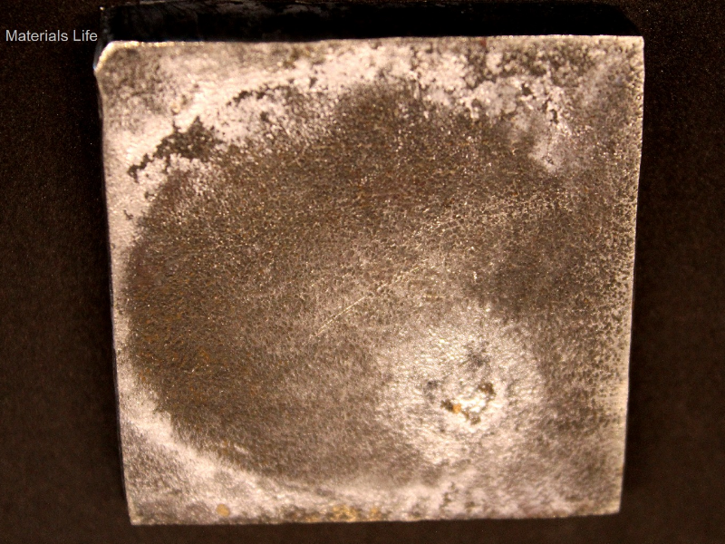 Other view of the 3/8" thick plate, 50 mm x 50 mm, of the AR500 wear resistant steel, in the face of impact with the projectile.  The plate did not suffer any macroscopic damage.  It was only stained at the impact surface.