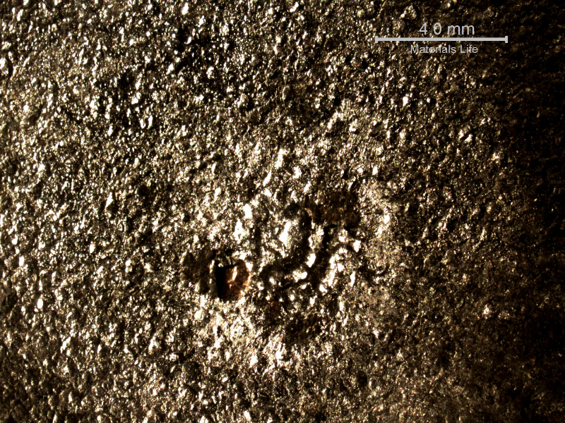 Detail of the position in the plate of impact with the projectile.  No damage, only particles adhered at the surface.