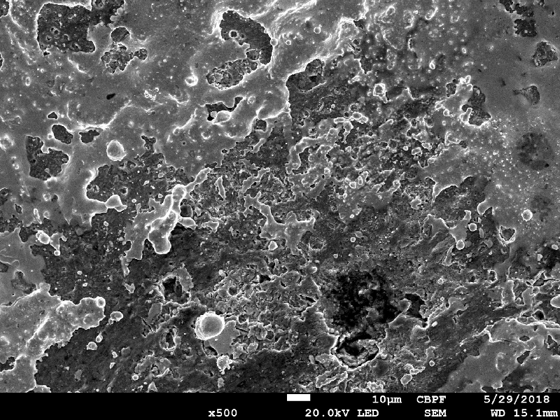 Aspect of the plate surface a little far from the region of bullet impact, by scanning electron microscopy, showing bullet melted islands on the surface. The EDS analysis showed Pb-Sb peaks.
