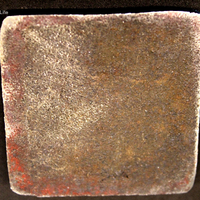 Aspect of the 3/8" thick plate, 50 mm x 50 mm, of the AR500 wear resistant steel, in the opposite face of impact with the projectile.  The plate did not suffer any macroscopic damage.