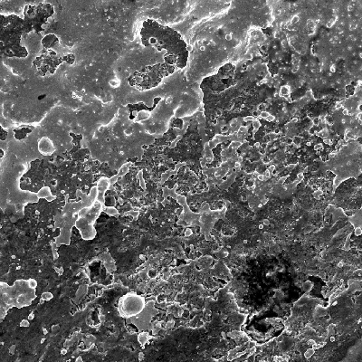 Aspect of the plate surface a little far from the region of bullet impact, by scanning electron microscopy, showing bullet melted islands on the surface.  The EDS analysis showed Pb-Sb peaks.
