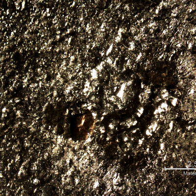 Macroscopically detail of the position in the plate where the projectile strike the plate.  No damage of the plate but foreign material (from the bullet) adhered at the surface.