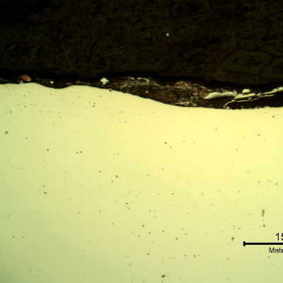 Micrography of the plate section, as polished, close to the surface that suffered the impact.  At this magnification it is possible to see a deposit over the plate surface, but no evidences of damage in the plate.