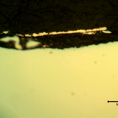 Micrographic detail of the plate section, as polished, close to the surface that suffered the impact.  The orange is the copper alloy melted film.