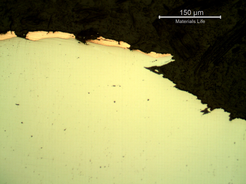 Micrographic detail of the plate section, as polished, close to the surface that suffered the impact. The copper alloy melted and created  a yellow-orange deposit.