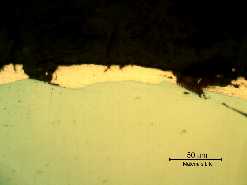 Micrographic detail of the plate section, as polished, close to the surface that suffered the impact. The copper alloy melted and created  a yellow-orange deposit.