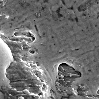 Detail of the melted Pb-Sb film over the hole surface.