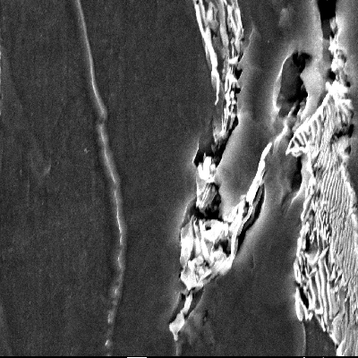 Micrographic detail of the ferritic-pearlitic structure close to the region where the projectile penetrate the plate. There are internal voids that are characteristic of a ductile microvoid formation.