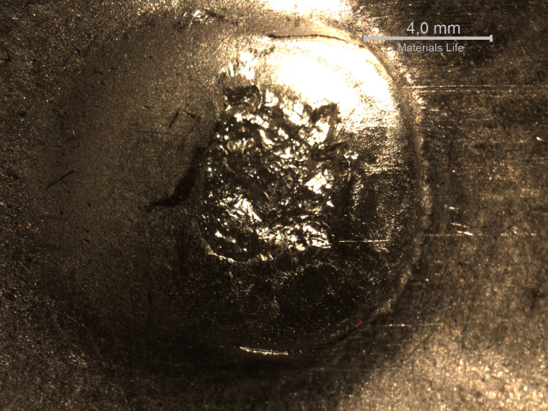 Detail of the position where the projectile strike the plate. The plate suffered a localized plastic deformation.
