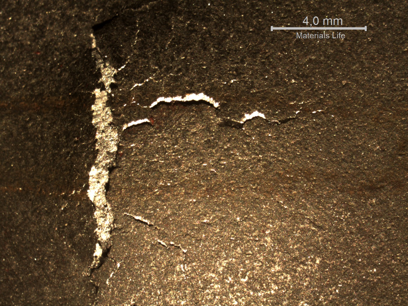 Detail of the position observed form the back side of the plate, where the projectile deformed the plate and cracked it.