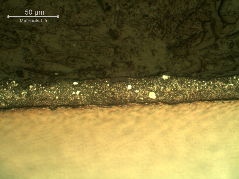 Micrography of the plate section, close to the surface that suffered the impact. The projectile melted and created a film at the surface.  HF+HNO3+H2O chemical etch.