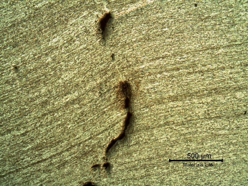 Micrography of the 3/8" thickness titanium alloy plate, in a section. The impact side of the plate is to the top of the figure. The plate was sheared through wall in a very localized position.  HF+HNO3+H2O chemical etch.