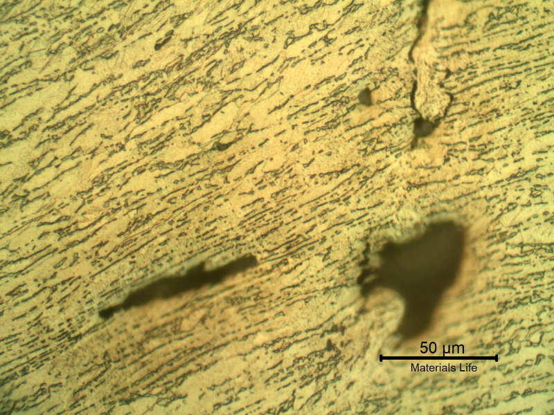 Micrographic detail of the damaged plate. The projectile sheared the plate but did not perforate it and created  longitudinal ductile secondary cracks.  HF+HNO3+H2O chemical etch.