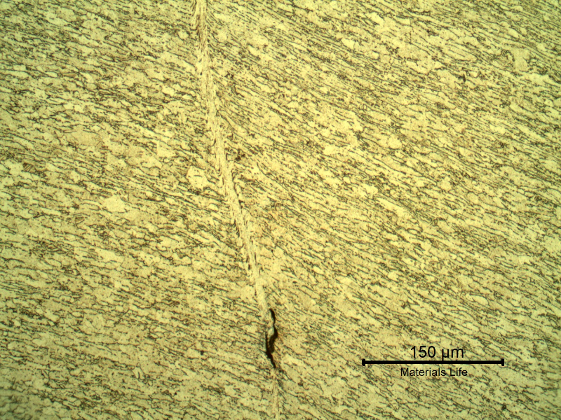 Micrographic detail of the shearing of the material due to the projectile impact.  It is a very localized plastic deformation effect.  HF+HNO3+H2O chemical etch.