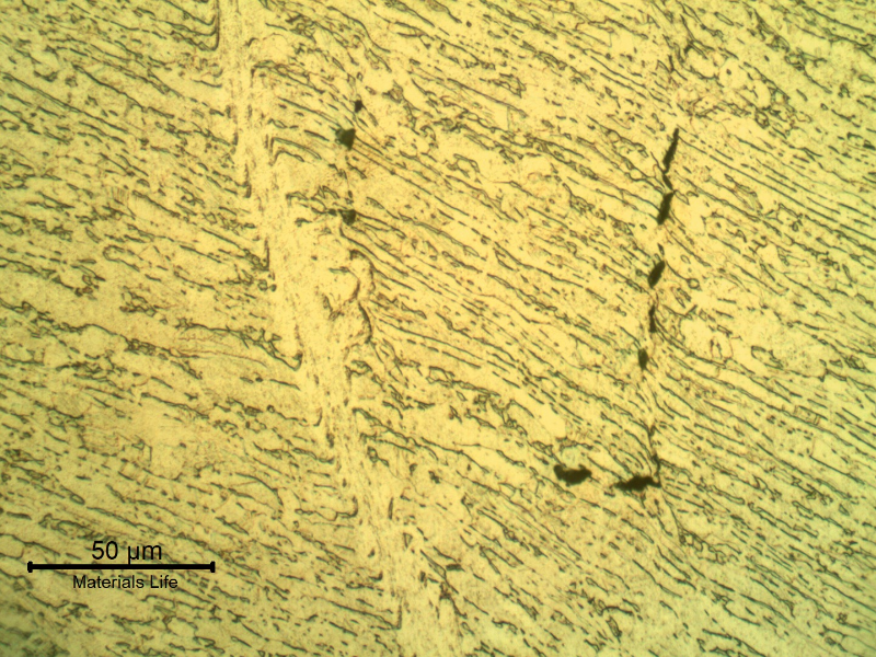 Micrographic detail of the shearing of the material due to the projectile impact.  It is a very localized effect.  HF+HNO3+H2O chemical etch.
