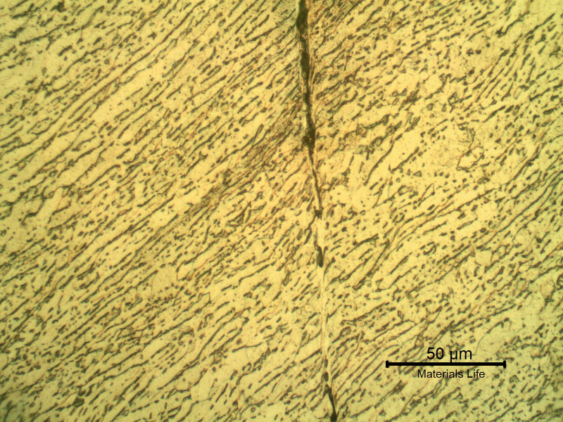 Micrographic detail of the shearing of the material due to the projectile impact.  It is a very localized effect.  HF+HNO3+H2O chemical etch.