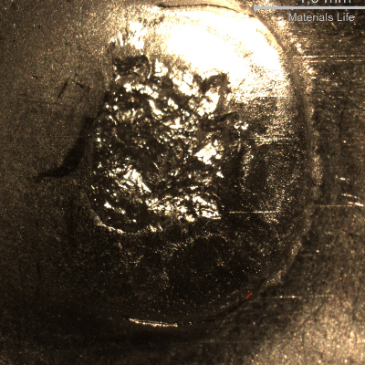 Detail of the position where the projectile strike the plate. The plate suffered a localized plastic deformation.