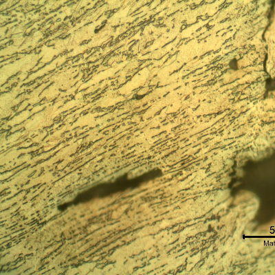 Micrographic detail of the damaged plate. The projectile sheared the plate but did not perforate it and created longitudinal ductile secondary cracks. HF+HNO3+H2O chemical etch.