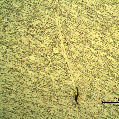 Micrographic detail of the shearing of the material due to the projectile impact. It is a very localized plastic deformation effect. HF+HNO3+H2O chemical etch.