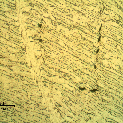 Micrographic detail of the shearing of the material due to the projectile impact. It is a very localized effect. HF+HNO3+H2O chemical etch.