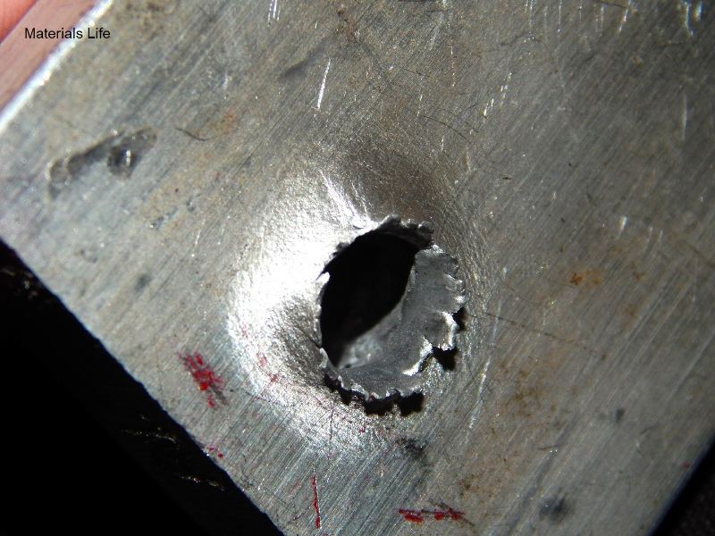Aspect of the 3/8" thickness plate, 50 mm x 50 mm, of the aluminum alloy plate, in the face of impact with the projectile. The plate was perforated by the bullet.
