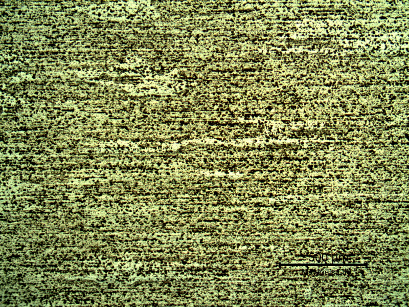 Micrography of the plate in a section, in the middle of the thickness. The aligned pitting is associated to the chemical etch of inclusions and second phases. The structure is granular but the grain boundaries do not appear at that magnification, originally 50x.