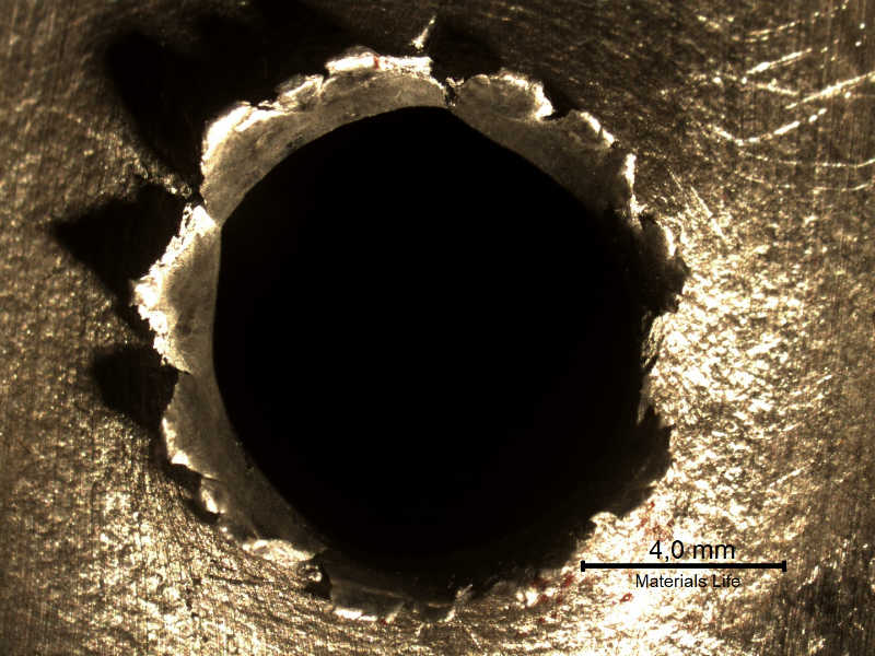Detail of the position where the projectile strike the plate. The plate suffered a localized perforation.