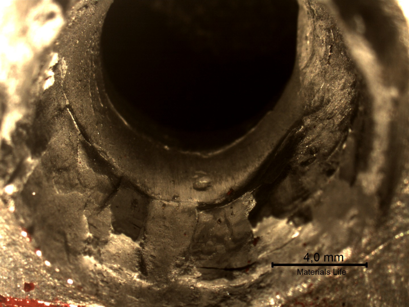 Detail of the position where the projectile exited the plate. The plate suffered a localized perforation.