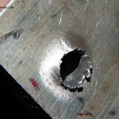 Aspect of the 3/8" thickness plate, 50 mm x 50 mm, of the aluminum alloy plate, in the face of impact with the projectile. The plate was perforated by the bullet.