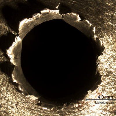 Detail of the position where the projectile strike the plate. The plate suffered a localized perforation.