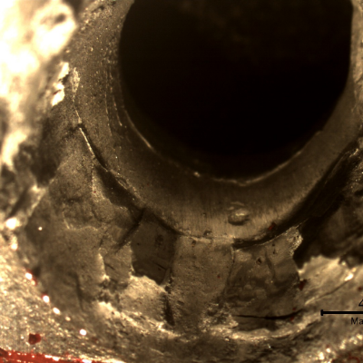 Detail of the position where the projectile exited the plate. The plate suffered a localized perforation.
