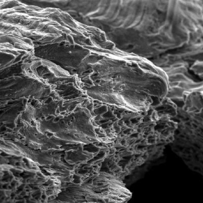 The fracture created by the projectile impact is fully ductile. The material presented a sheared surface with elongated dimples.