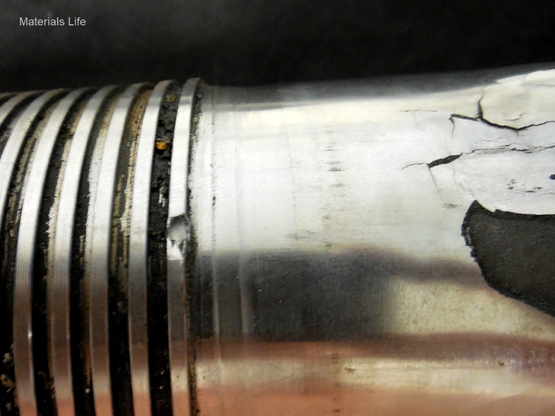 Aspect of the male part of the coupling, a pin, presenting the thermal spray layer detachment (right side of the figure). The pin was manufactured in a superduplex stainless steel tubular forging; the external surface was partially coated by thermal spray and machined. The sealing is only elastomeric but a coating is required to avoid galling between the two materials of the coupling.