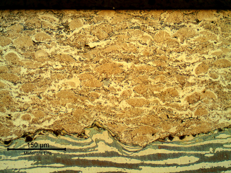 Micrographic detail of a longitudinal section of the pin, at the surface, evidencing the thermal spray layer, about 0.3 mm. The layer presents typical characteristics of multiple layers, low amount of entrapped oxides and pores. The interface presents a high roughness level for a good adherence and some entrapped oxides. The structure of the SDSS substrate did not show thermal effects.