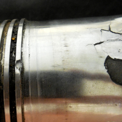 Aspect of the male part of the coupling, a pin, presenting the thermal spray layer detachment (right side of the figure). The pin was manufactured in a superduplex stainless steel tubular forging; the external surface was partially coated by thermal spray and machined.  The sealing is only elastomeric but a coating is required to avoid galling between the two materials of the coupling.