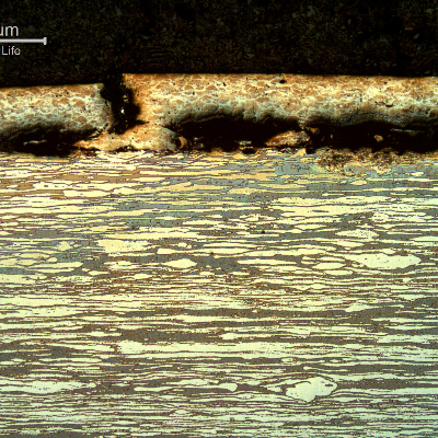 Micrography of a longitudinal section, at the damage surface of the pin, where the thermal spray layer was partially detached and broken.  The through layer breaking is ductile, typical of an overloading condition caused by the localized bending of the pin.