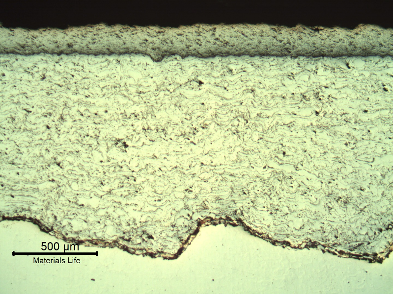 Micrography of a longitudinal section of the sleeve, in a region where the two layers applied by thermal spray are sound, not detached. The grey layer (200 micros) is the tugnsten carbide; and the white layer (1000 microns) is a stainless steel. The substrate is white in the bottom of the figure.