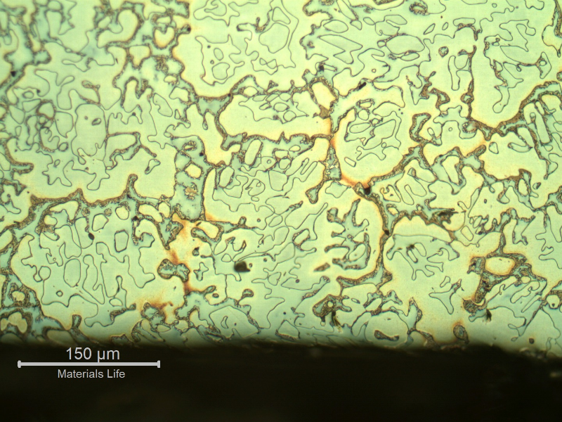 Micrography of the longitudinal section of the cast sleeve at the ID. The microstructure is duplex, austenitic and ferritic. The etch presents different colours for the phases. The yellow is associated to detrimental phases, like sigma, at the ferritic phase (ligh blue) and the white phase is the austenite.