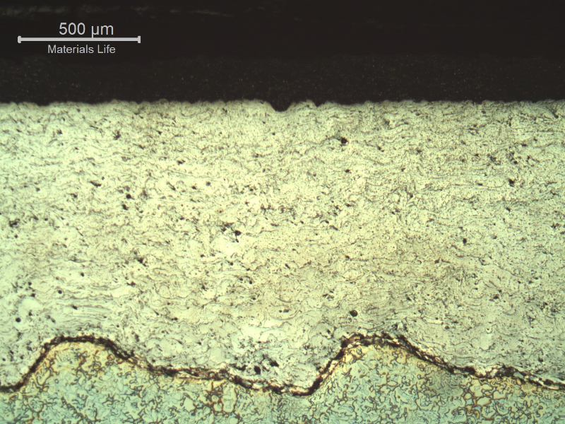 Micrography of a longitudinal section of the sleeve, at the external surface where there are two layers of coating.  The electrolytic etch evidenced the duplex stainless steel substrate (bottom of the figure) and the weave interface of the substrate and the first  thermal spray layer, about 1 mm thick, in a stainless steel. The surface layer, of tugnsten carbide, about 0.2 mm thick,  is black and not clearly visible in this figure.